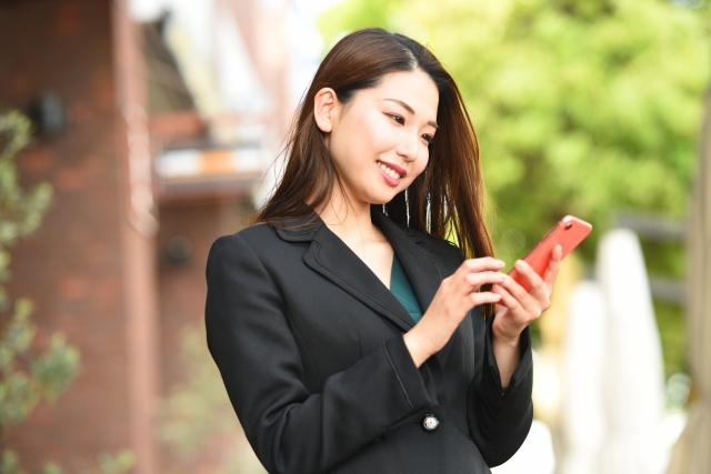 笑顔でスマホを操作する女性